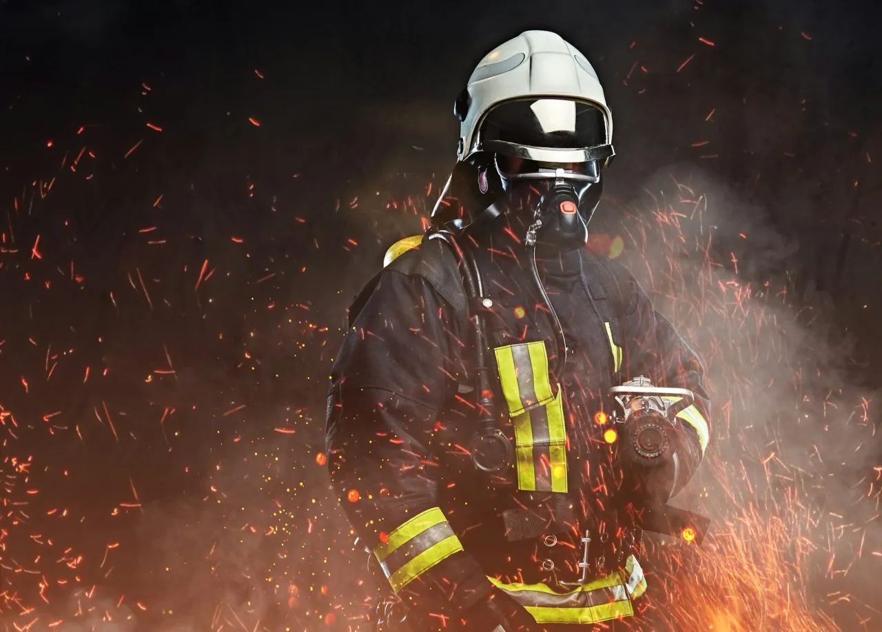 Fire Alarm & Fighting System - A Firefighter Dressed In A Uniform In A Studio - Fire Guyz